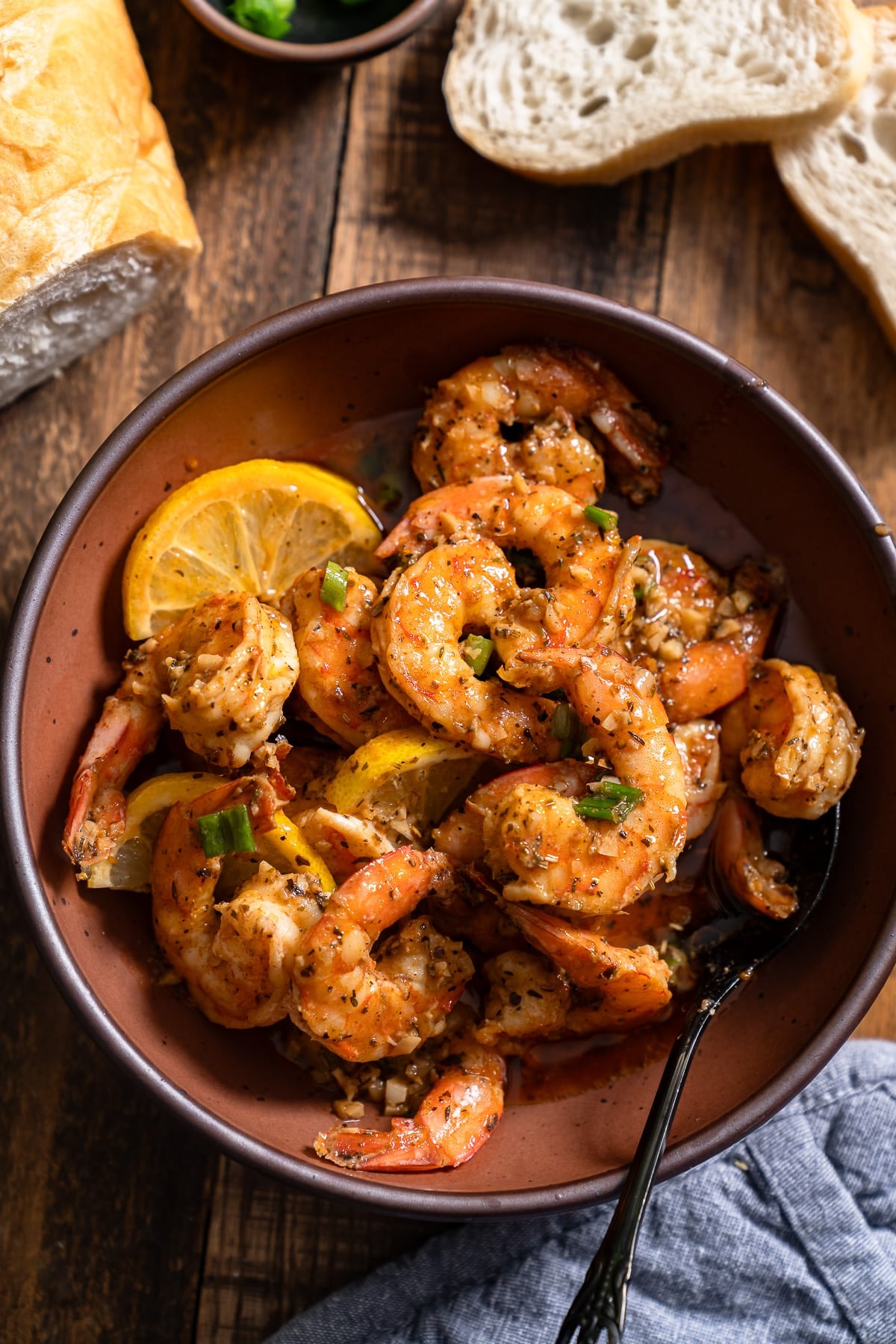 Orleans-style BBQ shrimp in a bowl surrounded by bread
