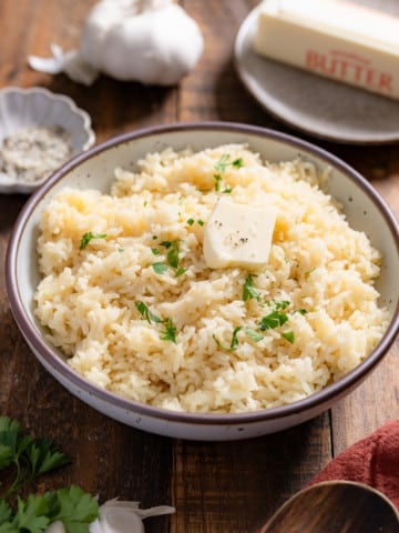 garlic butter rice with butter, head of garlic in background