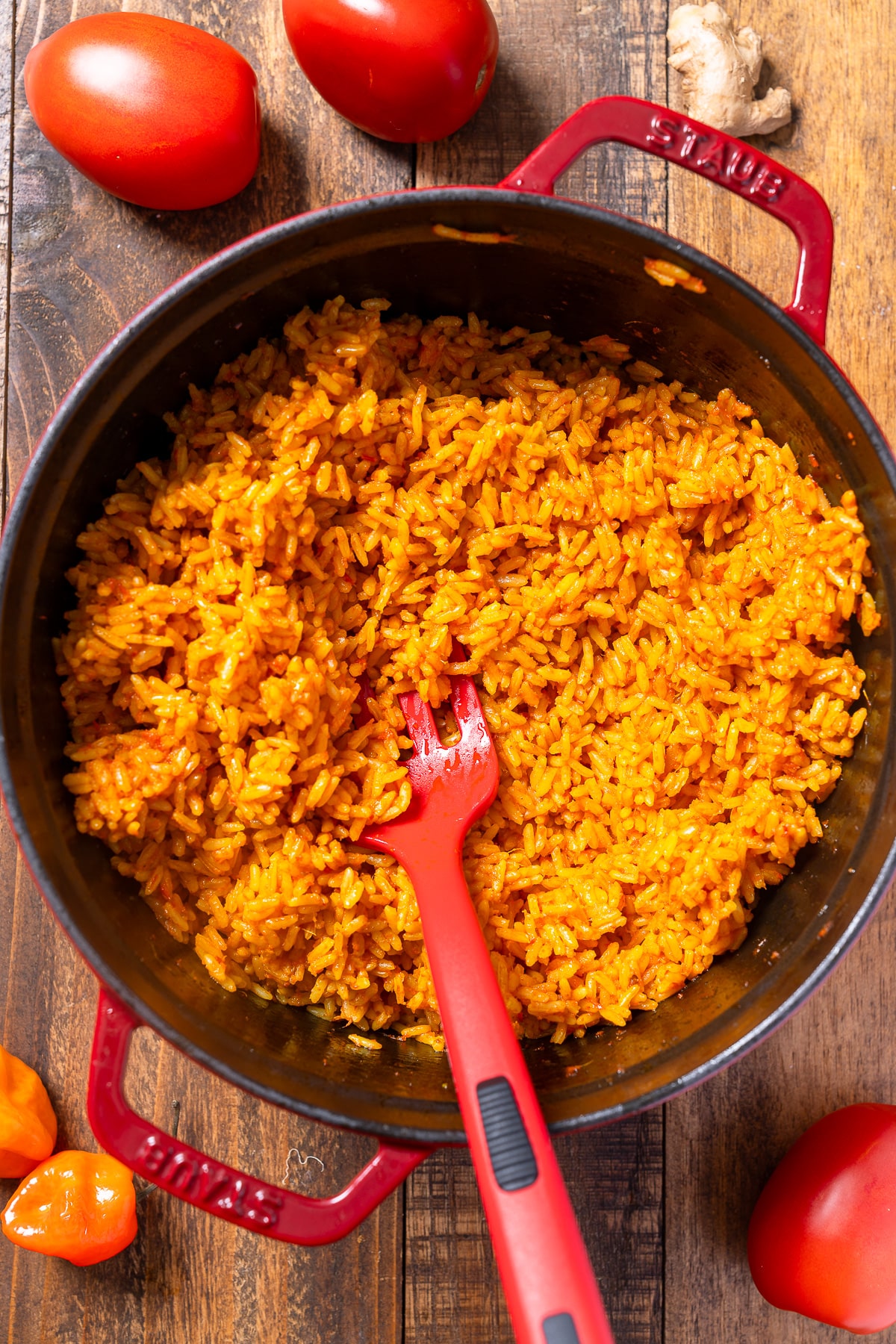 jollof rice in pot surrounded by tomatoes