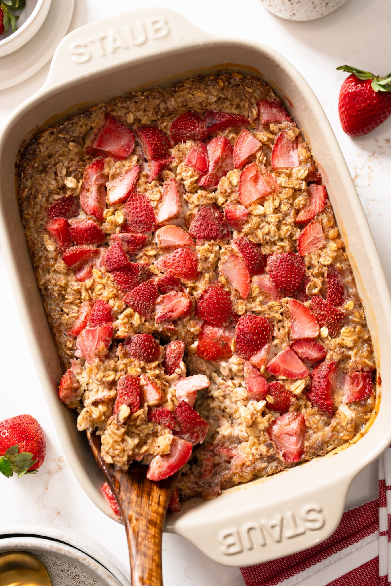 Strawberry baked oatmeal and baking dish with spoon sticking out