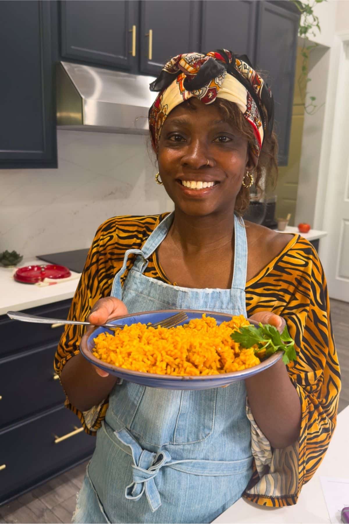 tanya holding jollof rice in kitchen
