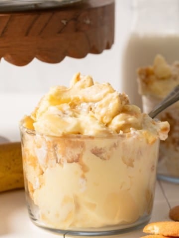 Banana pudding in a glass jar with a spoon sticking out