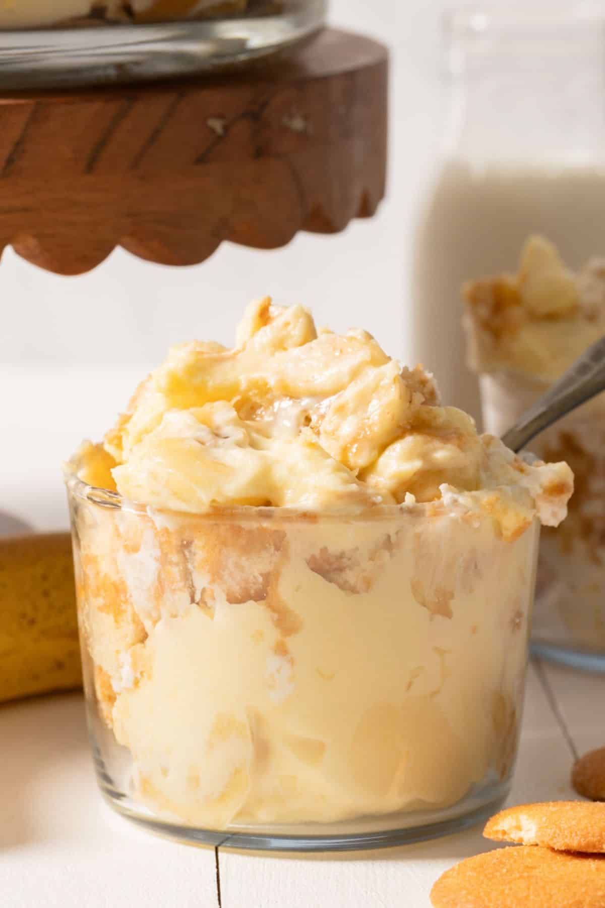 Banana pudding in a glass jar with a spoon sticking out 