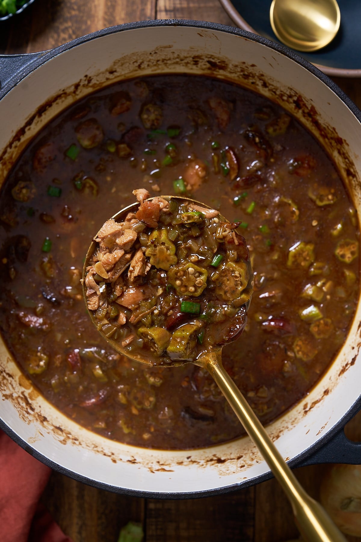 Spoon picking up gumbo out of pot