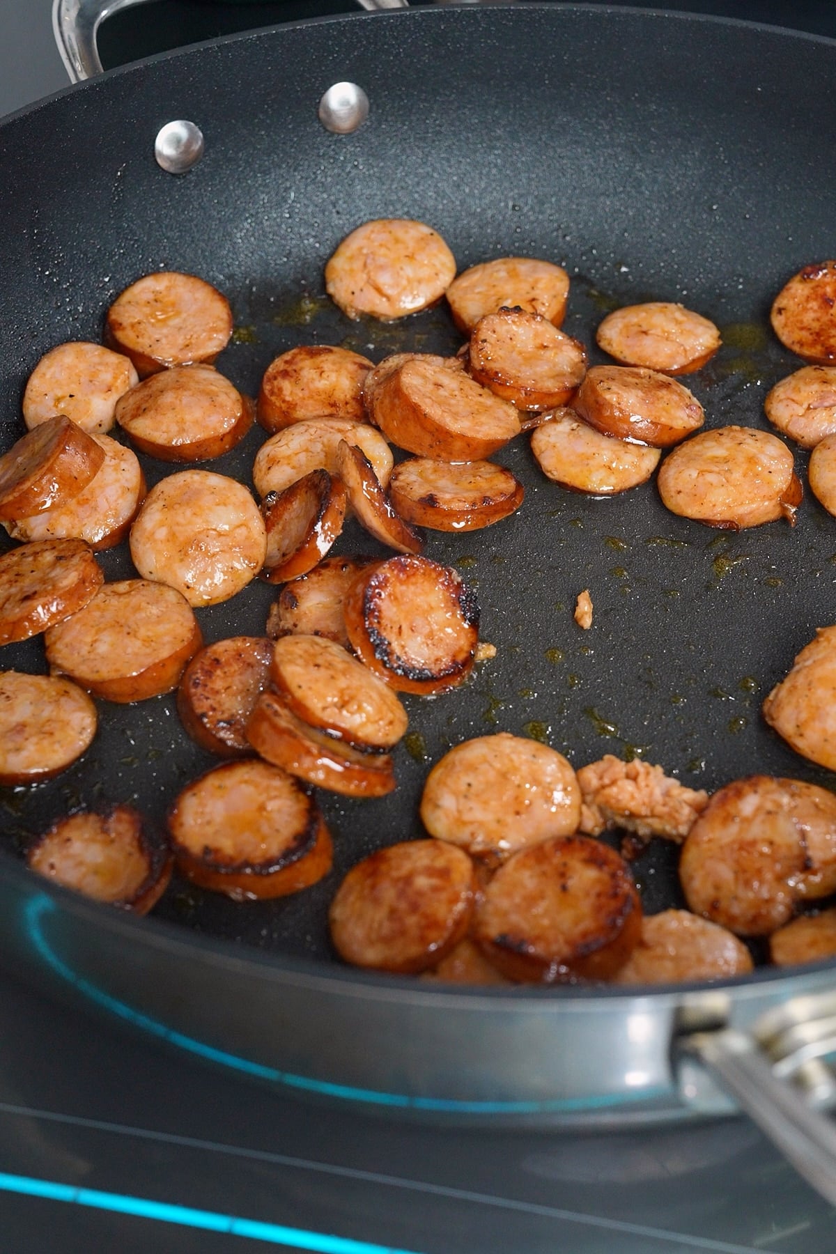 Browning and andouille sausage in skillet