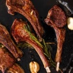 Lamb chops in skillet with rosemary and garlic.