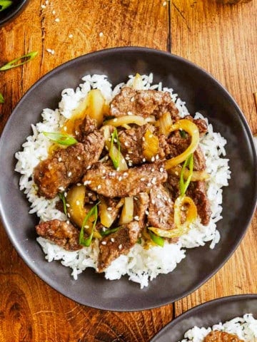 Mongolian beef in a bowl over some rice.
