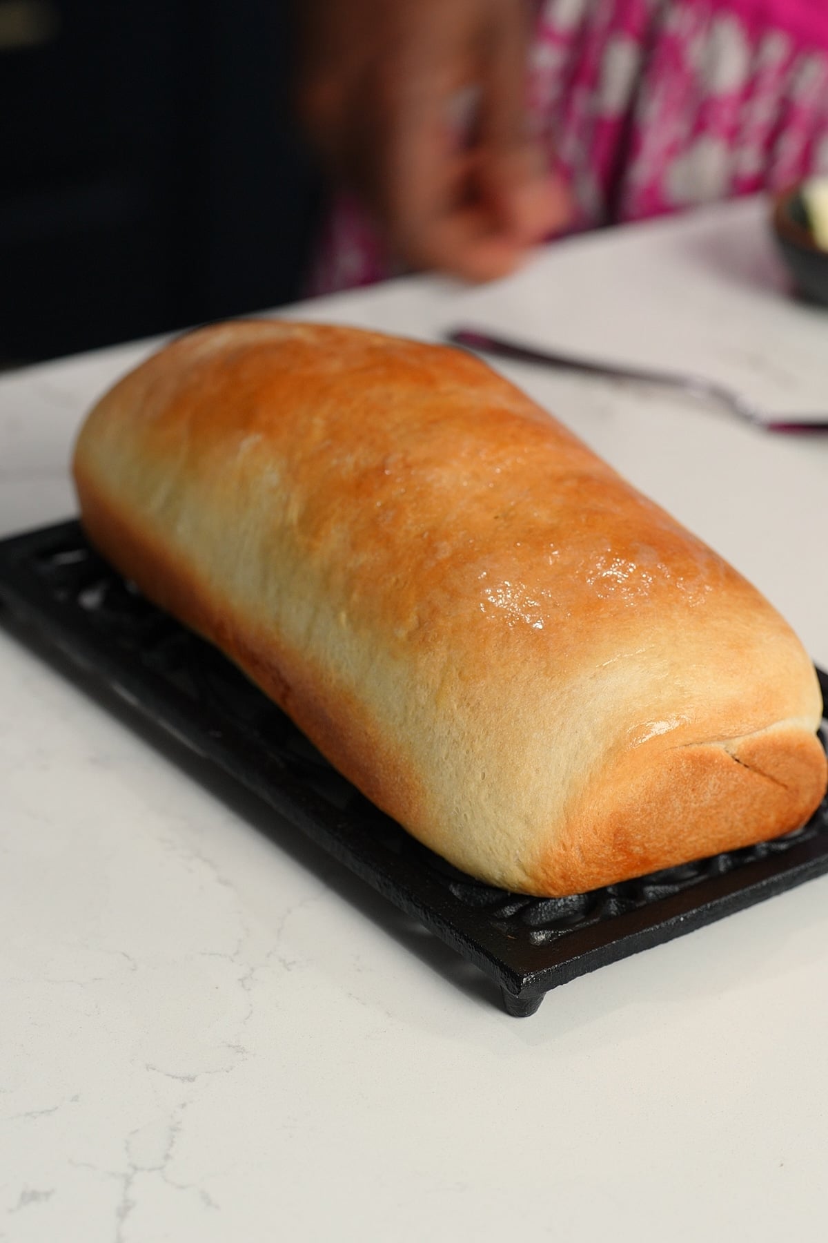 hardough bread cooling on rack with melted butter on top