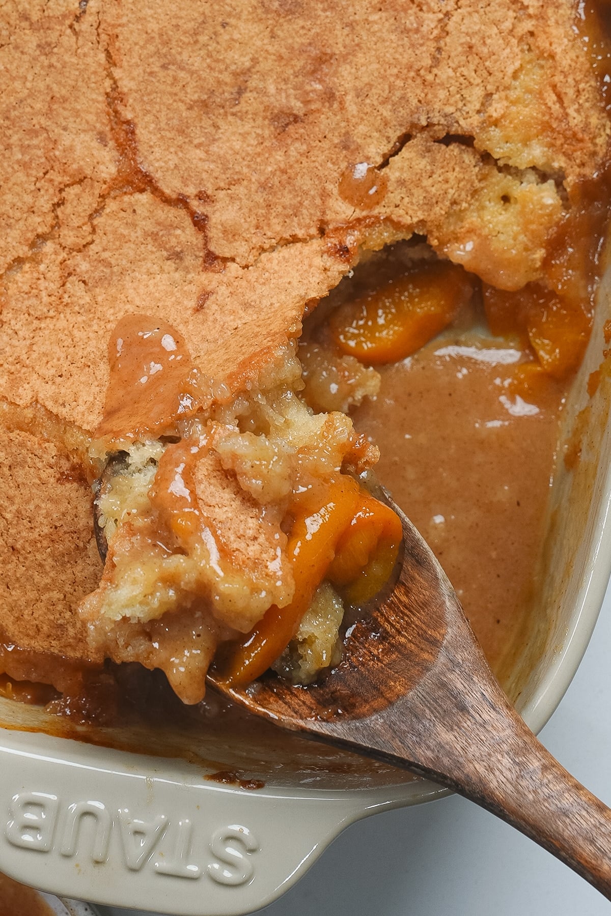 Spoon picking up peach cobbler