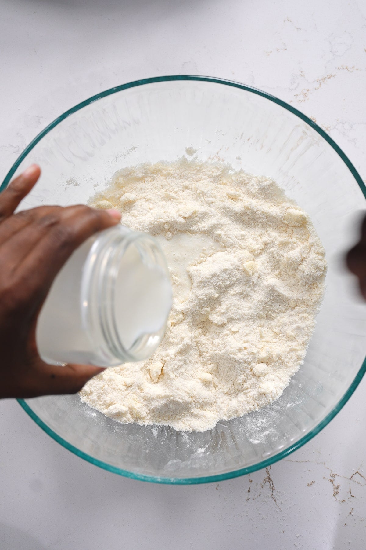 Milk being poured into flour