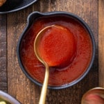 spoon lifting out sweet and sour sauce out of serving dish