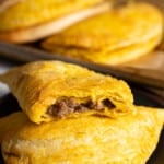 jamaican beef patties on plate, one open to see the inside