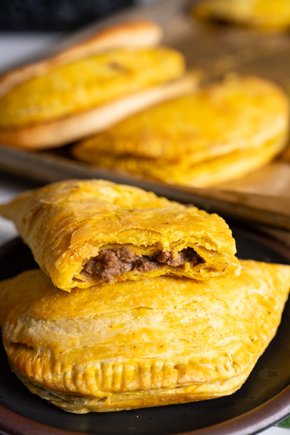 jamaican beef patties on plate, one open to see the inside
