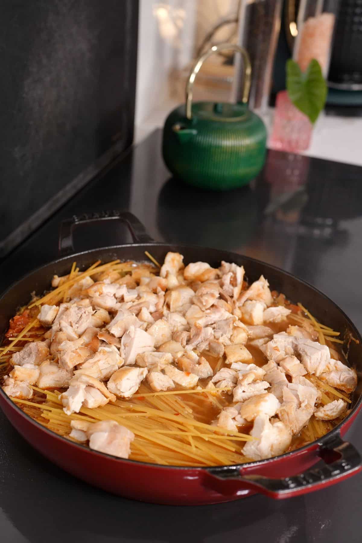 spaghetti in broken noodle pieces and chicken pieces