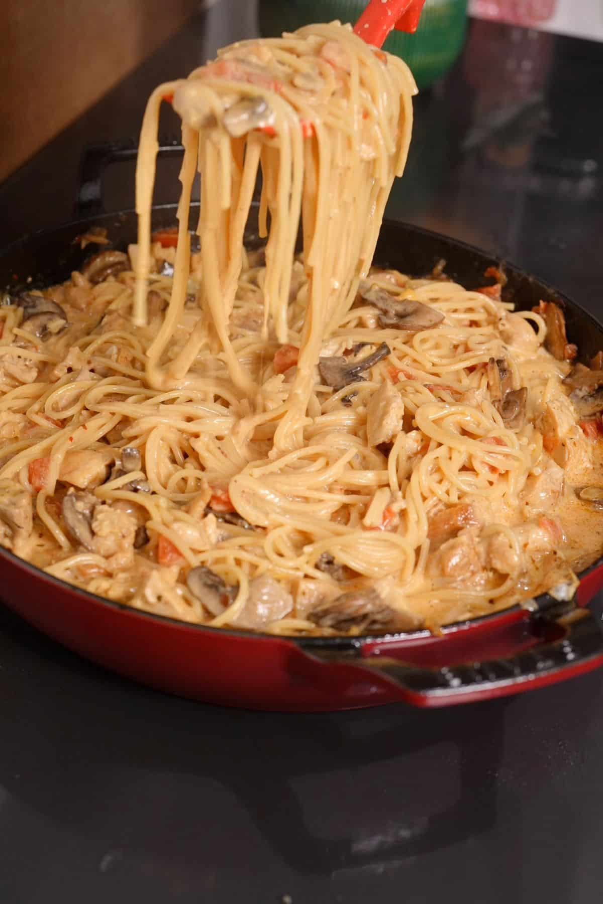 fork picking up chicken spaghetti fron skillet