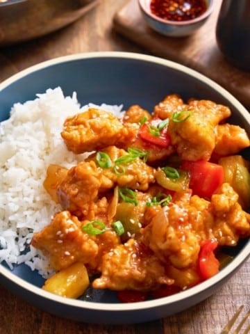swet and sour chicken in bowl next to rice
