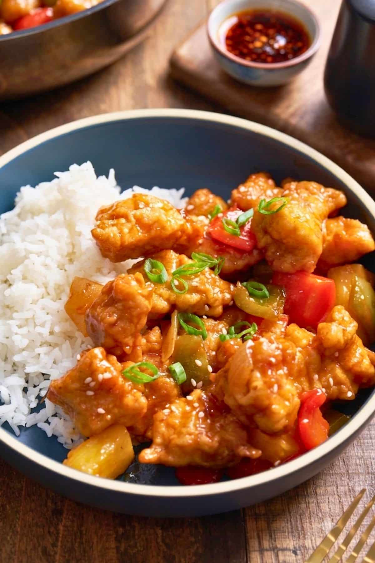 sweet and sour chicken in bowl next to rice