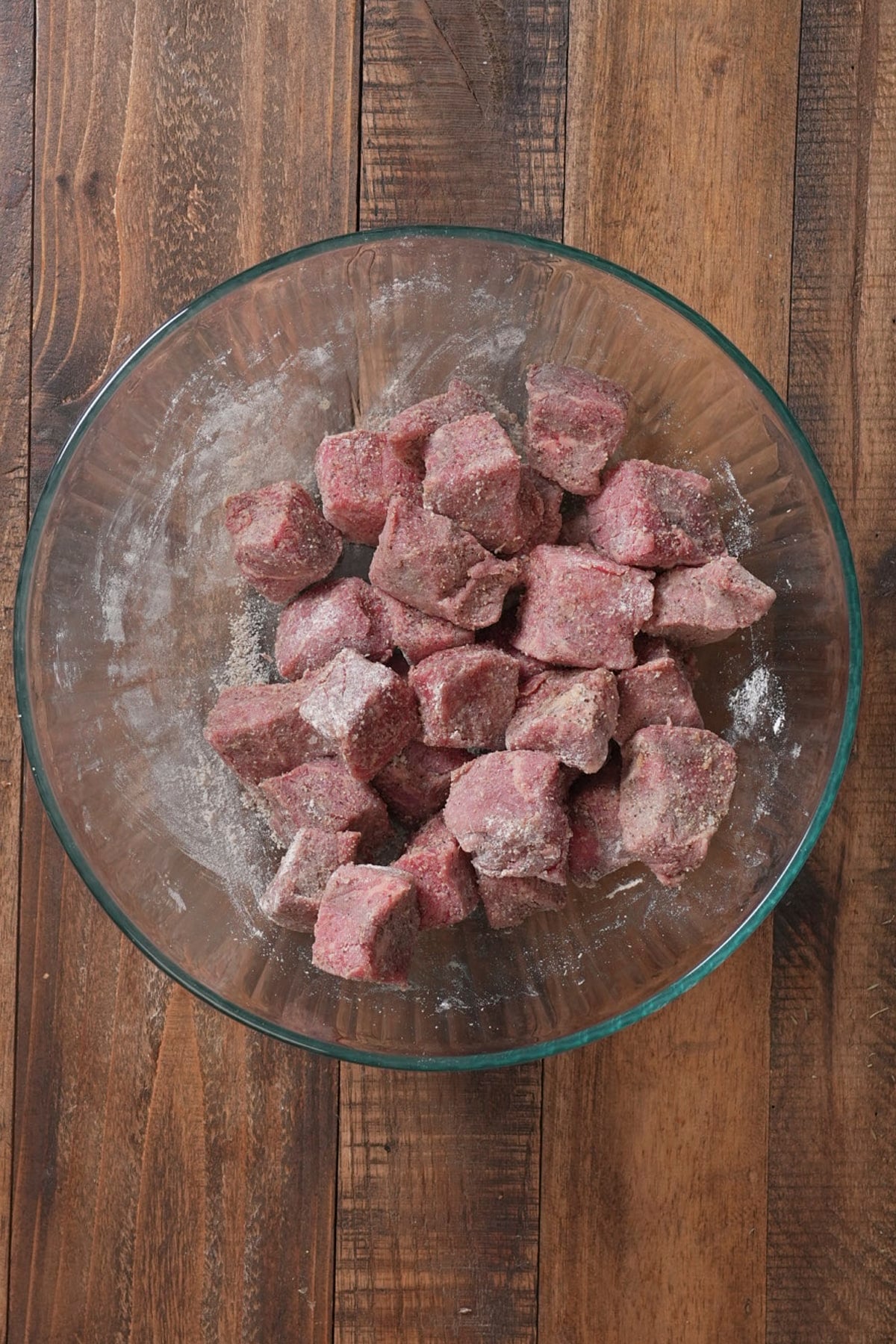 beef tips in bowl with seasoning and flour on it