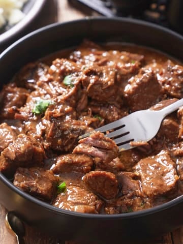beef tips with gravy with fork picking up beef