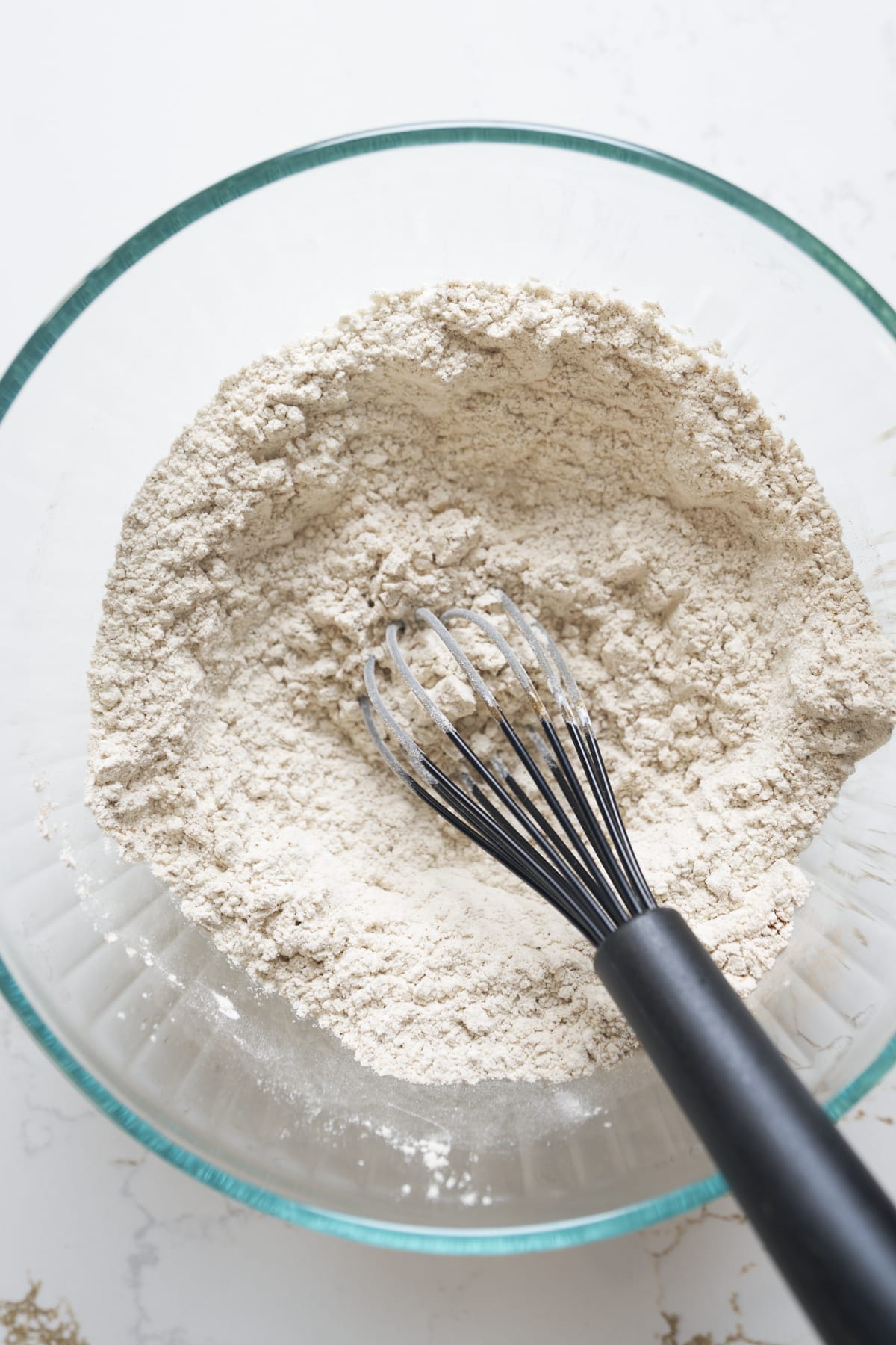 Flour, cornstarch, and pumpkin bread spices whisked together in a glass bowl