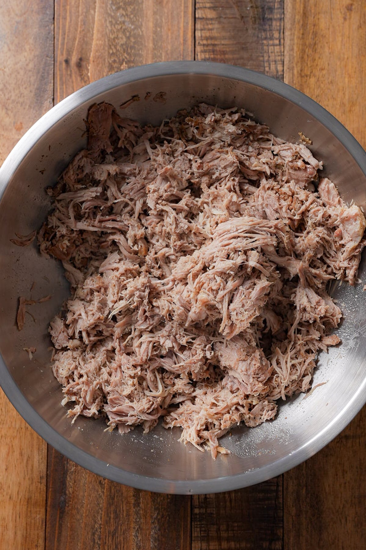 Pulled pork in metal bowl.
