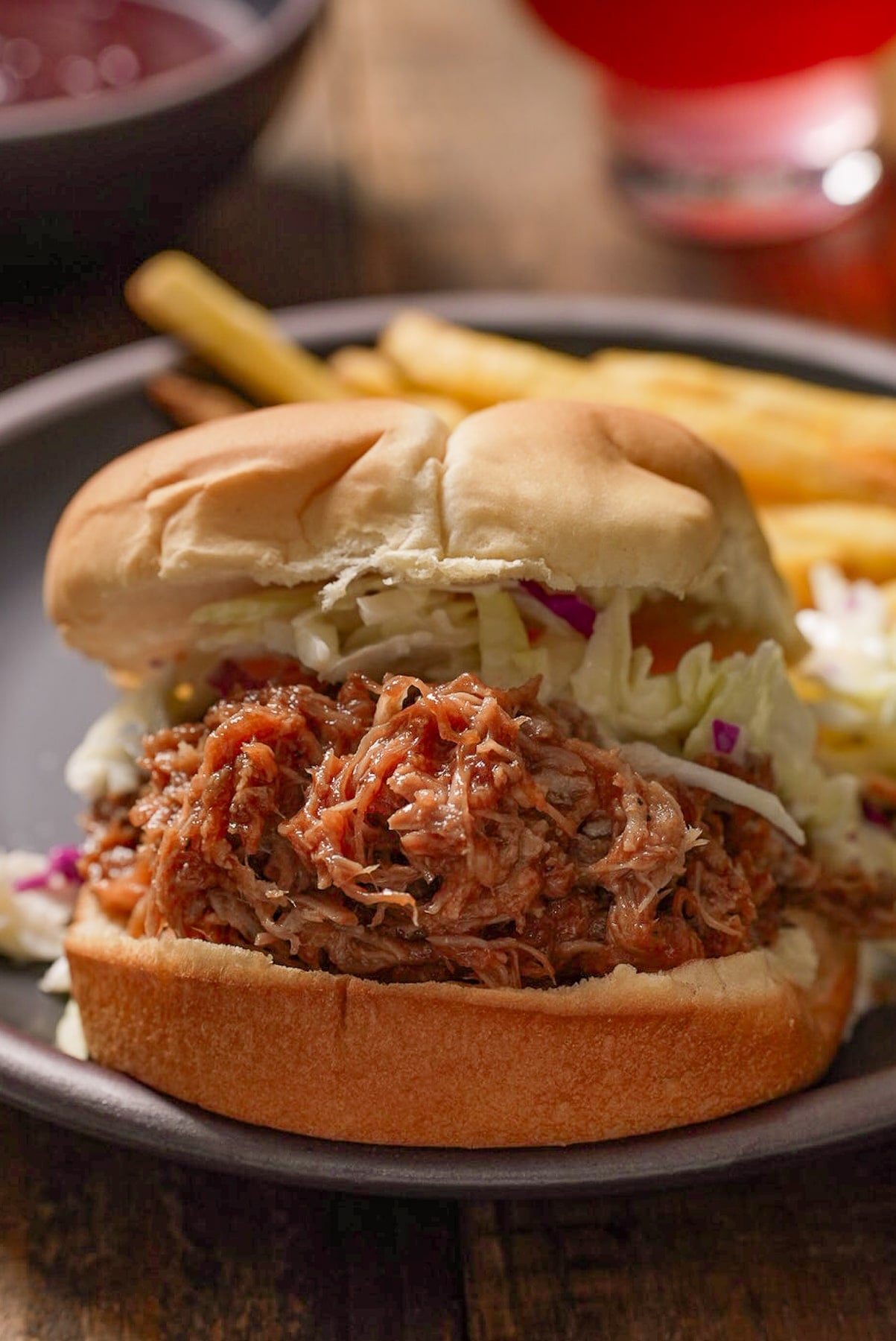 Pulled pork sandwich with barbecue and coleslaw on bread.