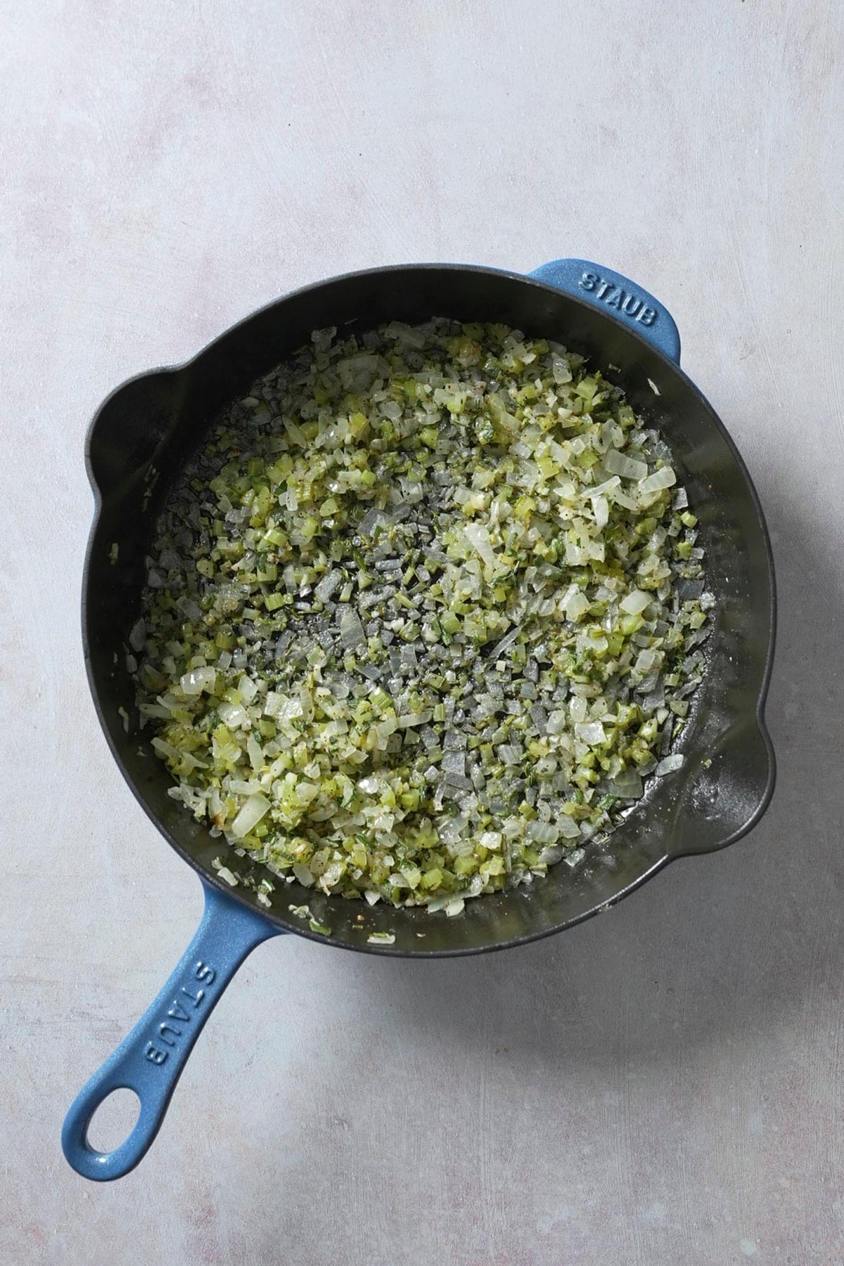 butter and onion, garlic, and celery with seasoning in skillet for stuffing