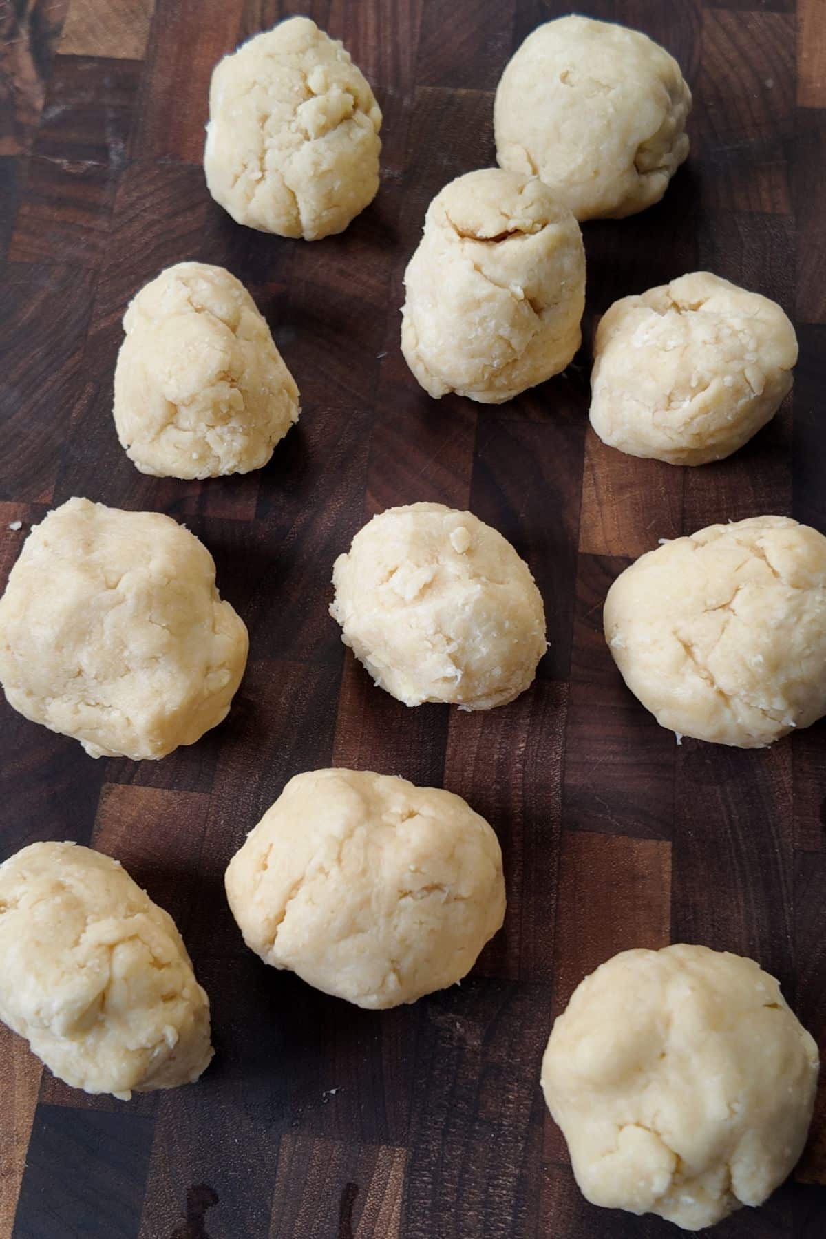 Rounds of dumpling dough resting on a wooden cutting board