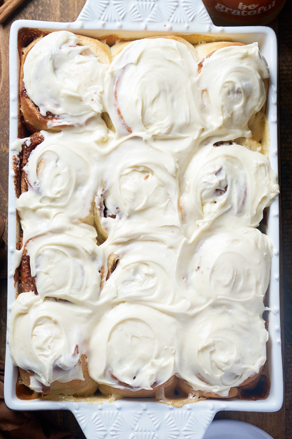 Freshly baked cinnamon rolls covered in cream cheese icing.