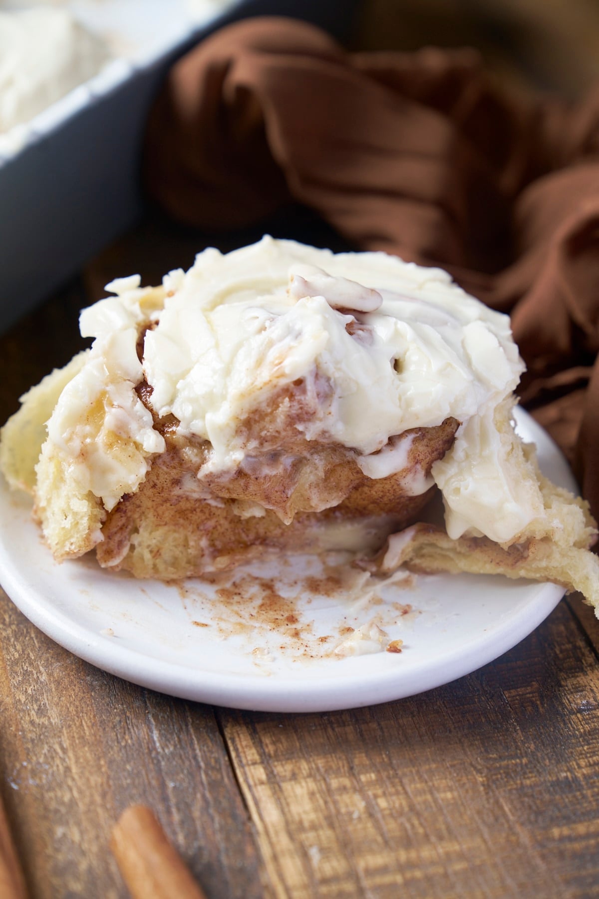 single cinnamon roll on plate broken in half