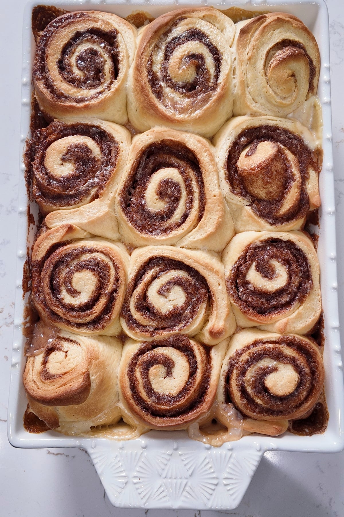 baked cinnamon rolls in white baking pan