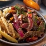 lomo saltado on plate with fries