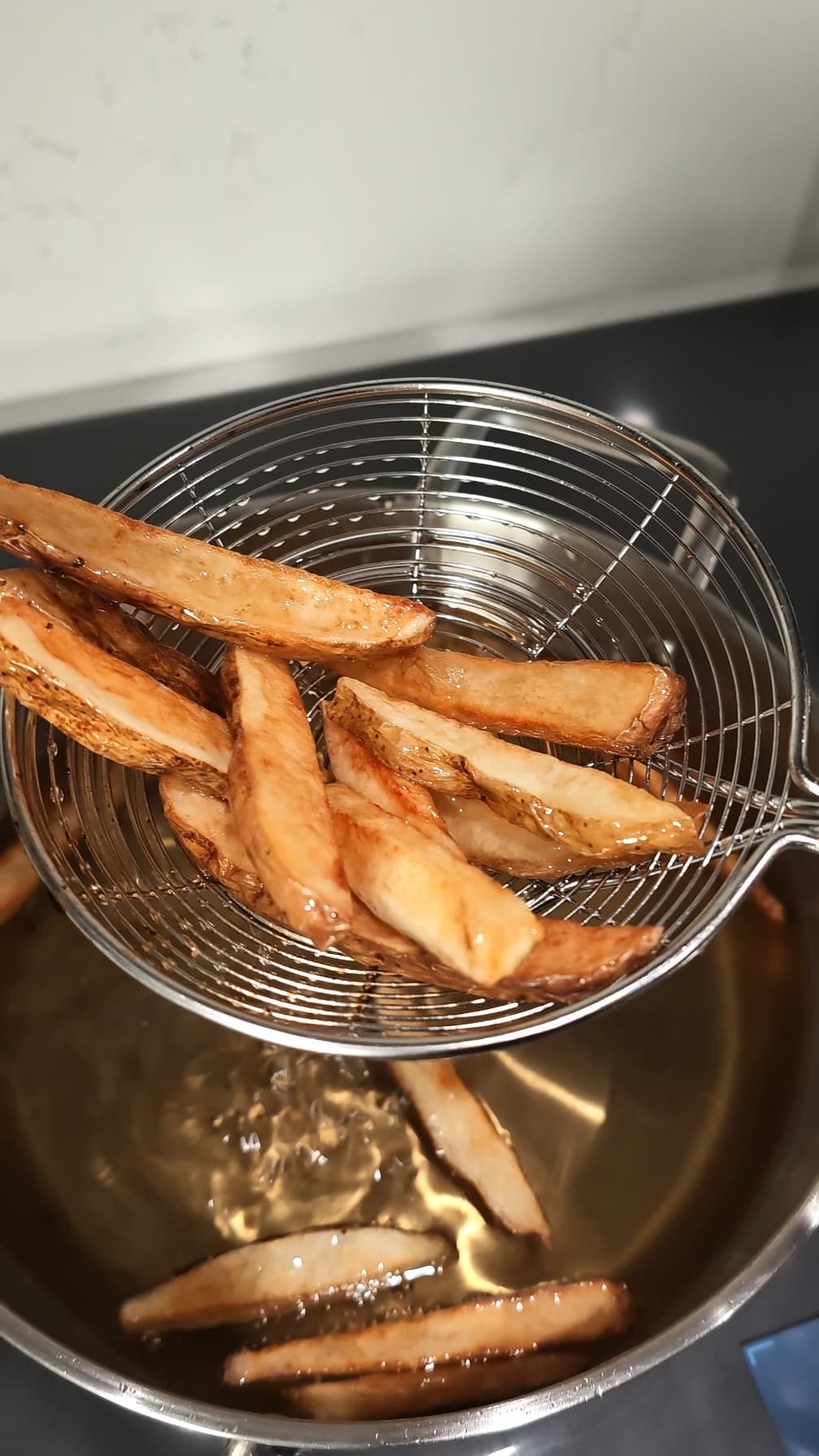fries being pulled out of hot oil