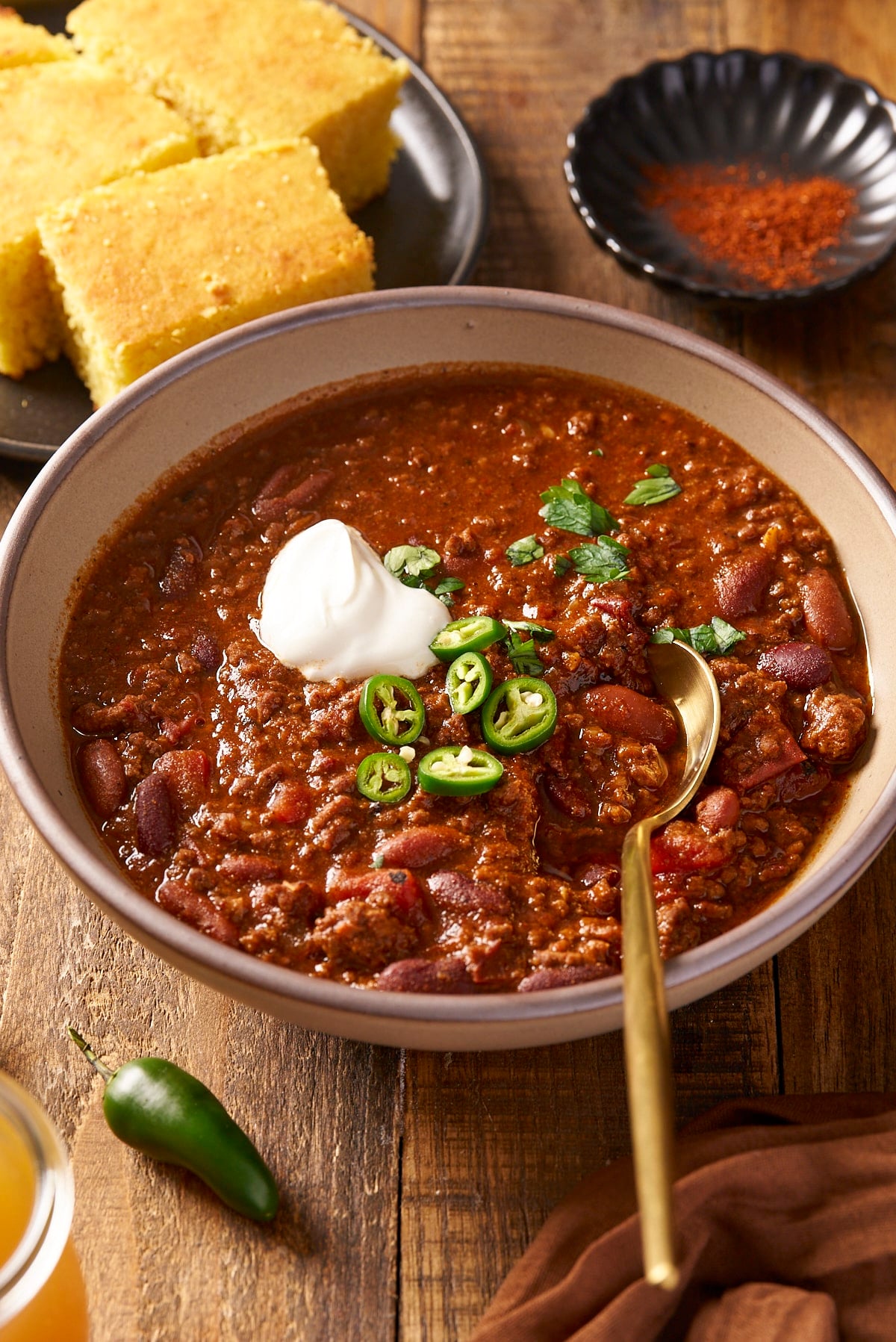 beef chili in bowl with cornbread in background
