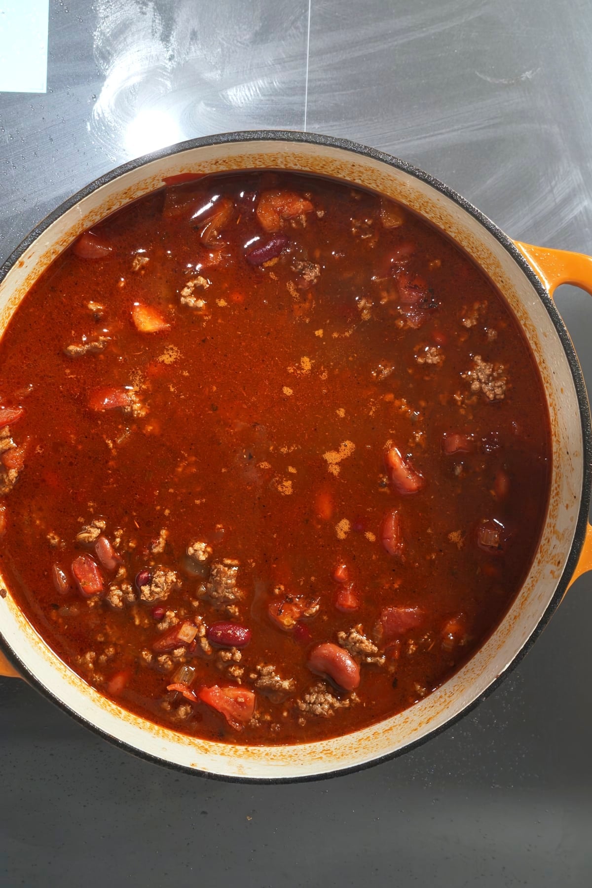 broth and adobo peppers added to the pot in this beef chili recipe