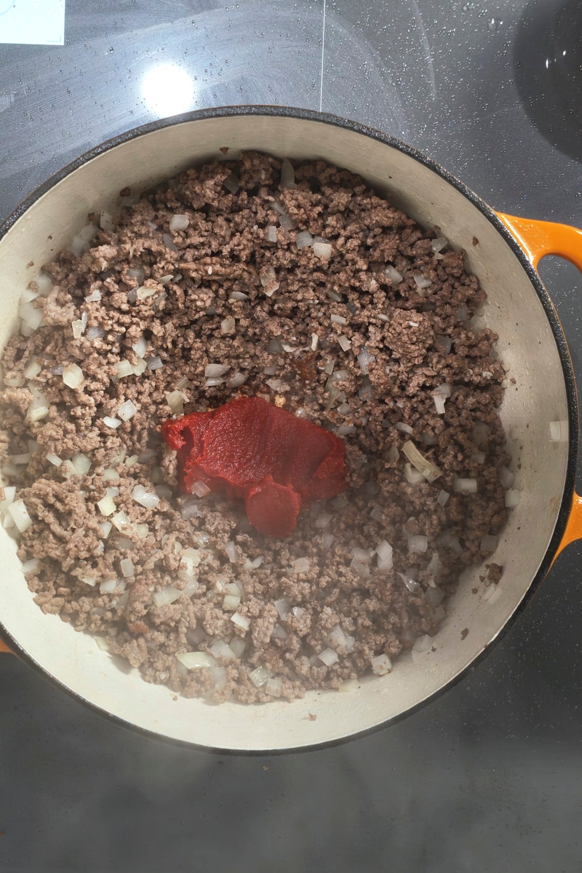 onions and garlic added to brown beef and tomato paste in it as well