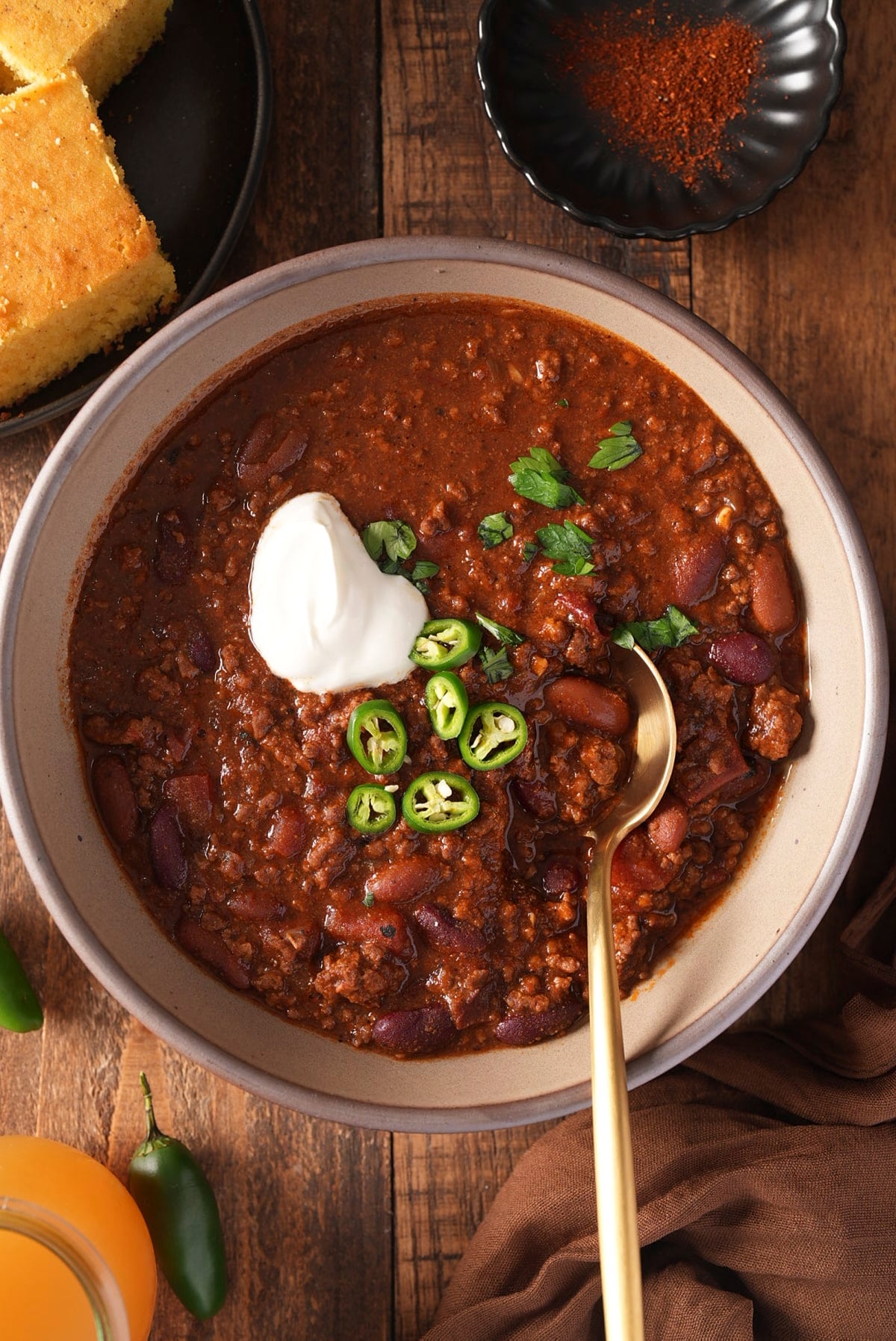 beef chili in bowl with toppings and spoon in it