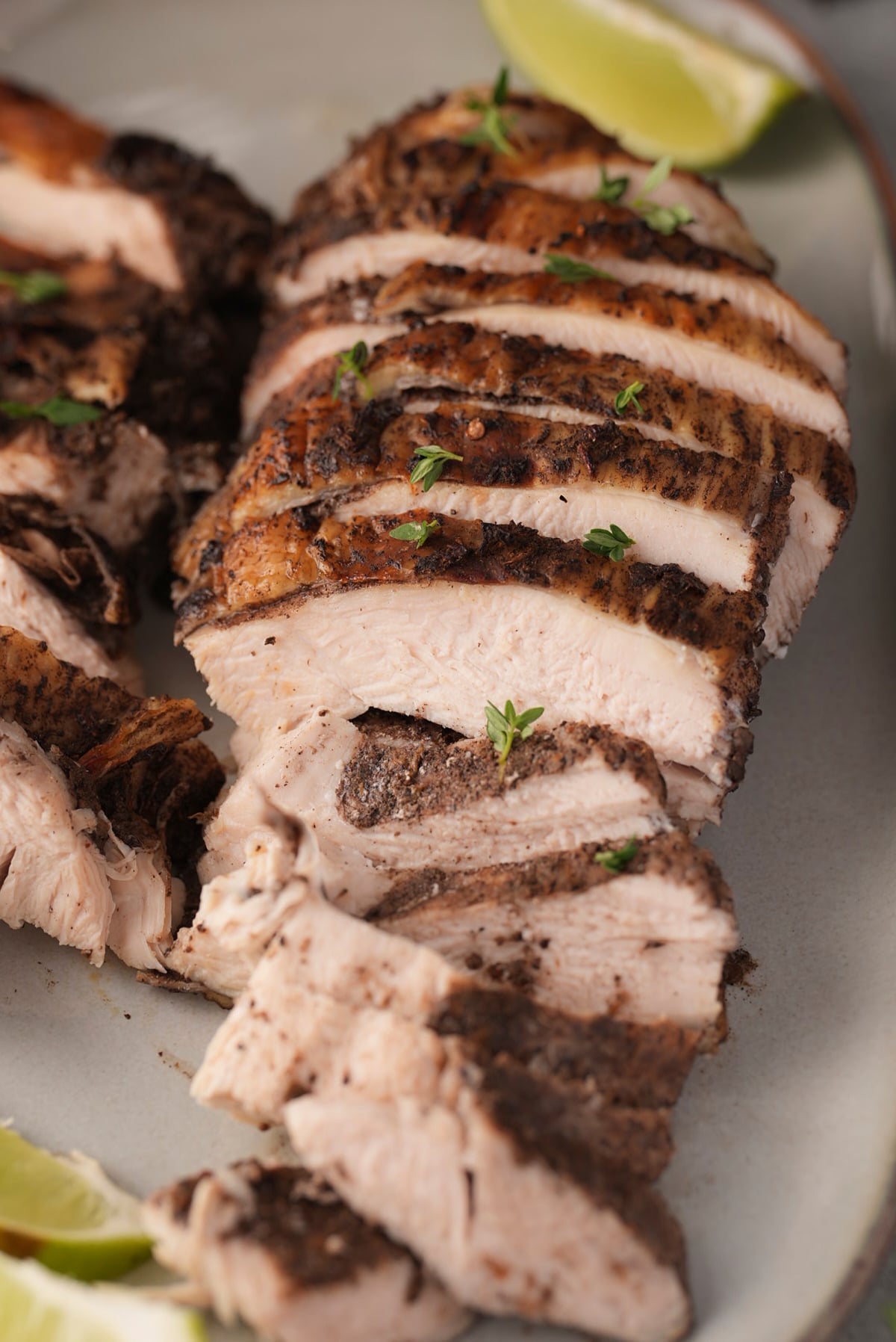Close-up of jerk turkey slices showing moist white meat and the dark seasoned edge.