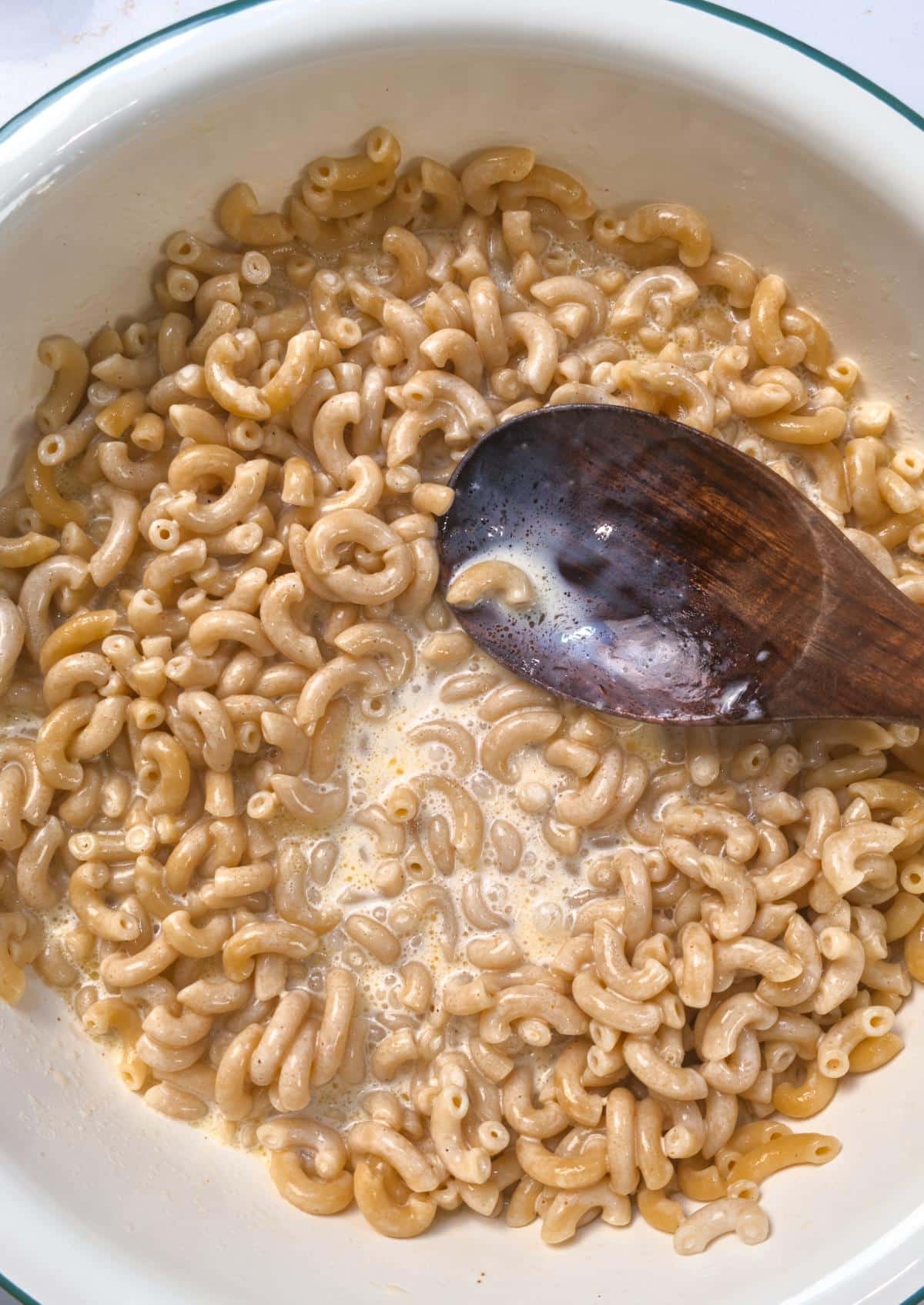 The egg and cream mixture poured over buttered macaroni and stirred with a wooden spoon.