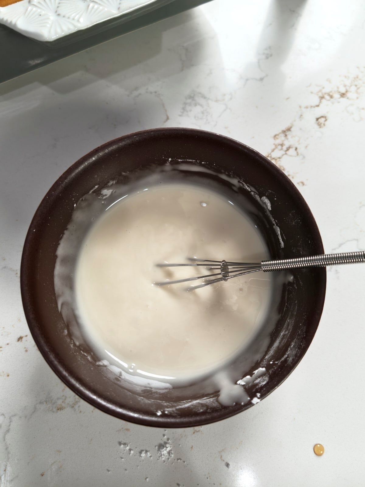Smooth white maple glaze whisked in a bowl.