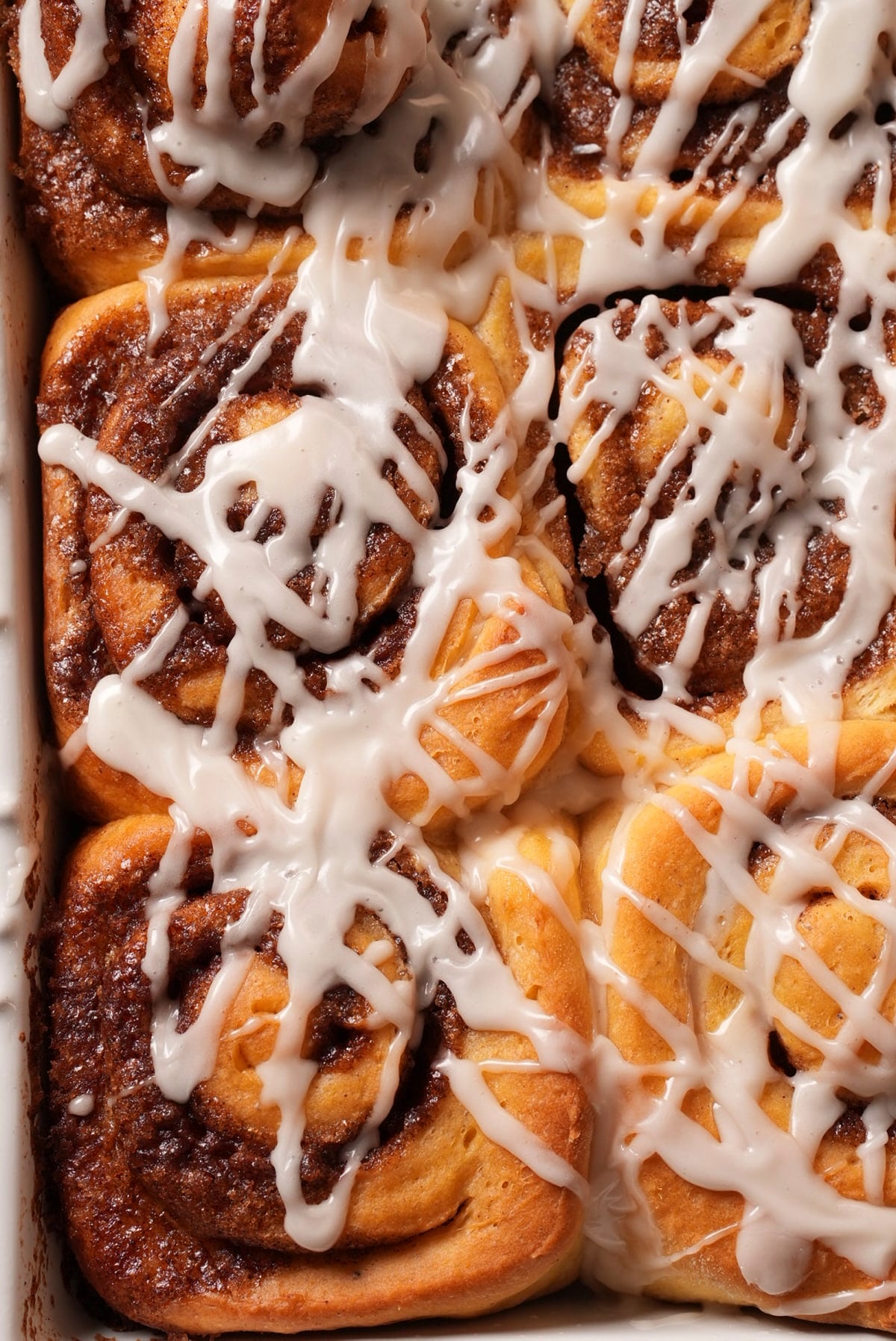 Close-up of soft glazed cinnamon rolls with brown sugar filling in the swirls.
