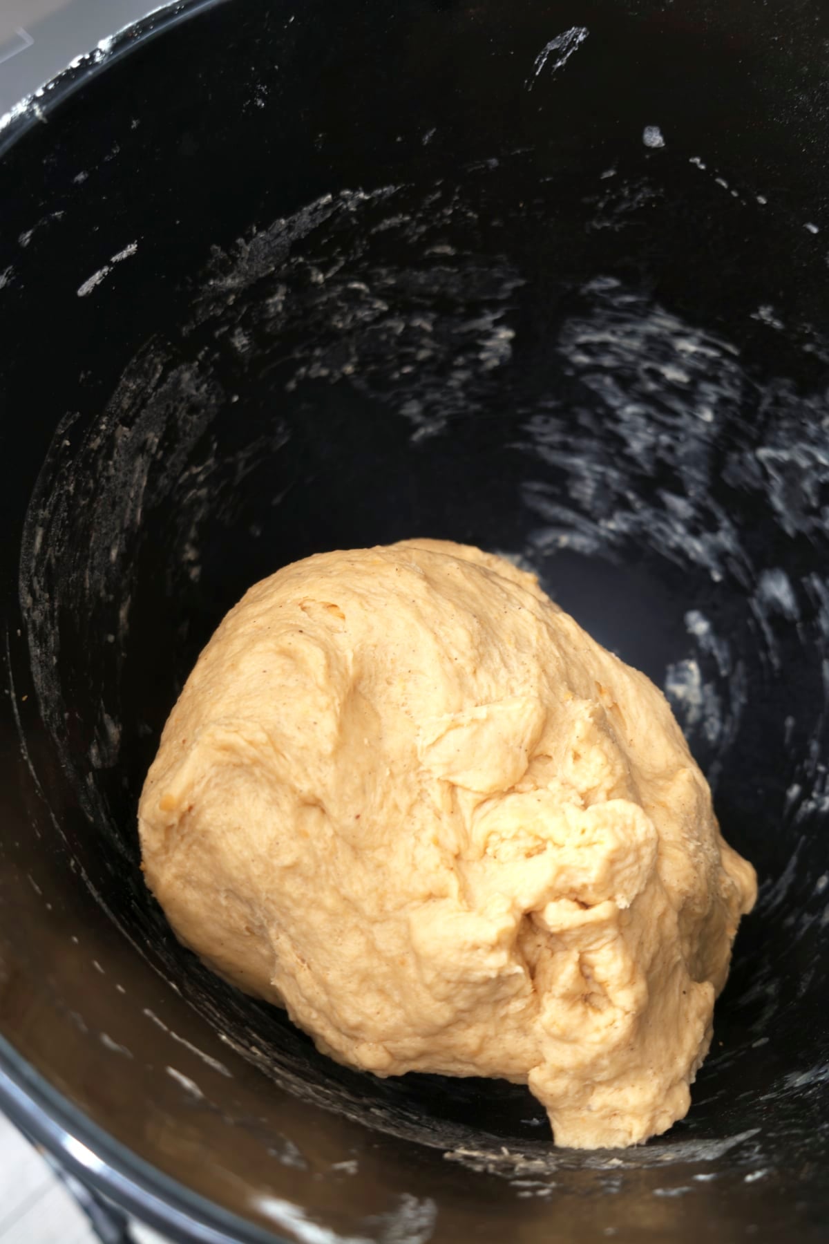 Smooth, soft dough gathered into a ball in the mixer bowl after kneading.