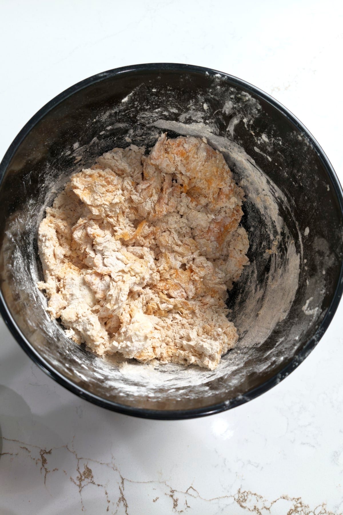 Rough, shaggy dough in a stand mixer bowl after the first mix, before kneading.